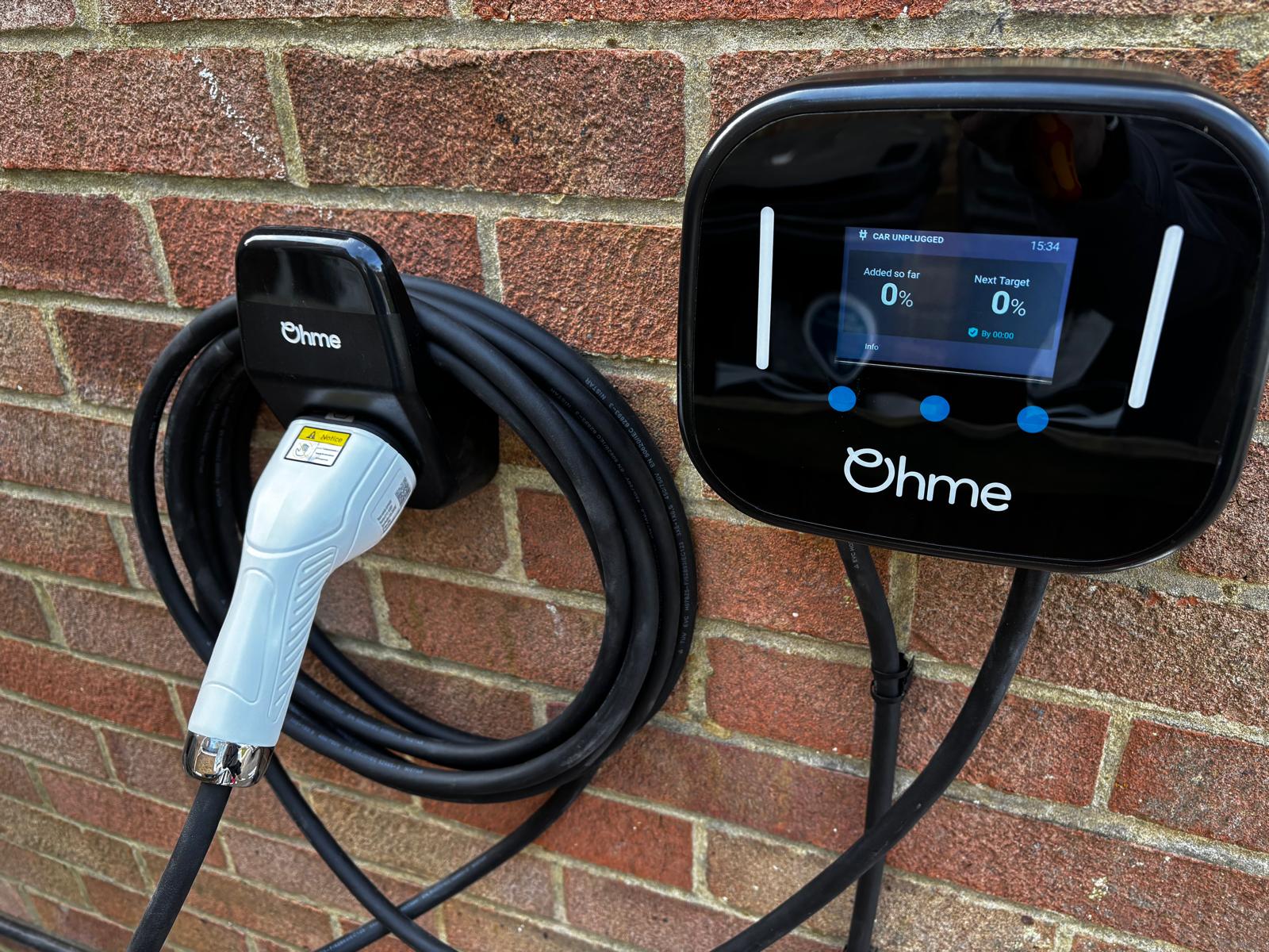 Ohme Home Pro electric vehicle charger installed on a brick wall